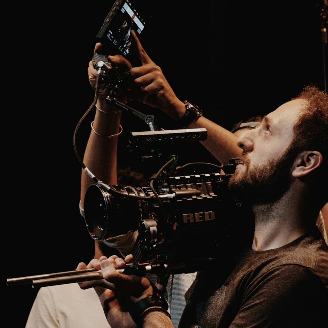 Camera operator filming with a professional broadcast video camera